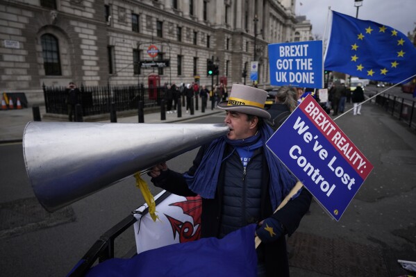 FILE- Anti-Brexit protester Steve Bray demonstrates on the edge of Parliament Square across the street from the Houses of Parliament, in London, Wednesday, Dec. 8, 2021.  (AP Photo/Matt Dunham, File)